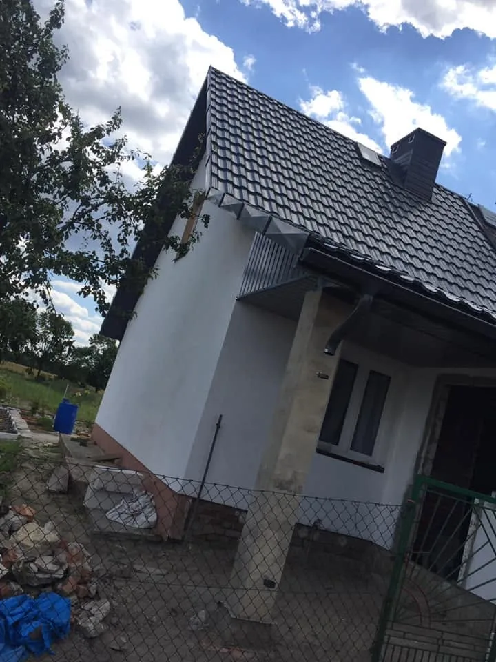 Dach kryty dachówką z oknem połaciowym, widok z boku budynku