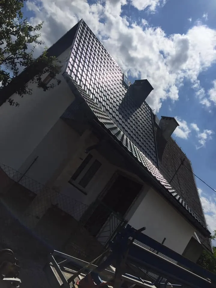 Dach kryty blachą w trakcie montażu, odblask słońca na połaci